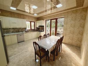 a dining room with a table and chairs in a kitchen at Big villa ISK in Gabala