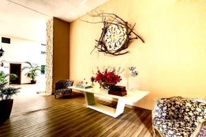 a living room with a table with flowers on it at Apartamento Villa Siena Condomínio À Beira Mar próximo ao Aeroporto in Salvador