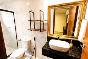 a bathroom with a white toilet and a mirror at Apartamento Villa Siena Condomínio À Beira Mar próximo ao Aeroporto in Salvador