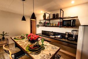 a kitchen with a table with flowers on it at Apartamento Villa Siena Condomínio À Beira Mar próximo ao Aeroporto in Salvador +16 photos
