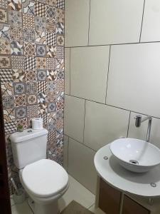 Pântano GrandeにあるCasa Ampla e Aconchegante no Centro de Pantano Grande!の白いトイレと洗面台のあるバスルーム