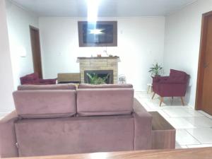 Pântano GrandeにあるCasa Ampla e Aconchegante no Centro de Pantano Grande!のソファと暖炉のあるリビングルーム