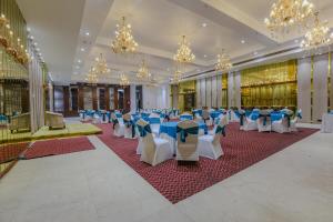 a banquet hall with blue and white tables and chairs at Aceotel Select Aria, Bhopal -A Luxury Boutique Hotel in Bhopal