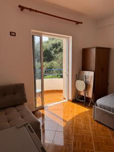 ein Wohnzimmer mit einer Couch und einer Glasschiebetür in der Unterkunft Harbour View Stay in Himarë + 6 Fotos