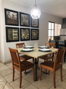 a dining room with a table with chairs and a chandelier at Acogedor apartamento minimalista Mai in Puerto Vallarta