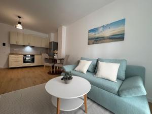 a living room with a blue couch and a table at A&A Appartment 2 in Timişoara
