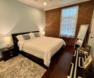 a bedroom with a large bed and a brick wall at In the Heart of Town-3BR-2bath-500Mbps WiFi-4car parking-EV-boat in Florence