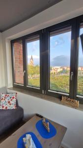 a living room with three windows and a table at Ferienwohnung Hafenpanorama Speicherresidenz Barth 4 5 in Barth