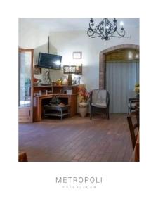 ein Wohnzimmer mit einem Kronleuchter, einem Tisch und einem Stuhl in der Unterkunft Casa Vacanza la Sorgente da Manu in Palombella