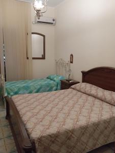 ein Schlafzimmer mit zwei Betten und einem Spiegel in der Unterkunft Casa Vacanza la Sorgente da Manu in Palombella