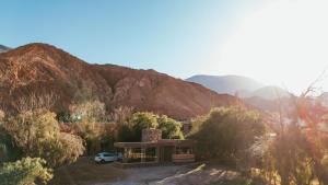 a house in the middle of a mountain at Red Hill Lodge Purmamarca in Purmamarca