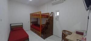 a room with two bunk beds and a table at Krui penginapan jokowi in Krui