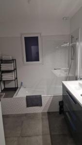 a bathroom with a shower and a tub and a sink at Au cœur des pierres dorées in Bully +6 photos