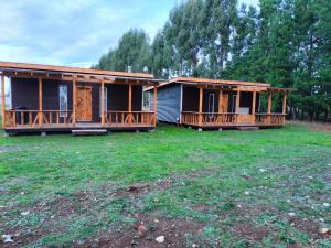 two modular homes with decks on a yard at Cabañas Los Tatas in Puerto Octay