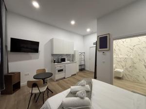 a white room with a bed and a table and chairs at Gabika Apartment 1 in Bilbao