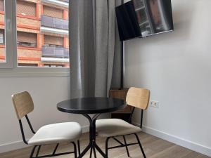 a table and two chairs in a room with a window at Gabika Apartment 1 in Bilbao