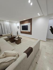 a large living room with a couch and a tv at Appartement luxueux et cosy Marina Saïdia in Saidia 