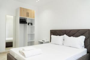 a bedroom with a large white bed with white pillows at Villa Merkaj in Sarandë