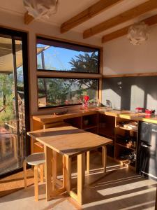 a kitchen with a wooden table and a large window at Santuario Cosmico Mamalluca in Vicuña +17 photos