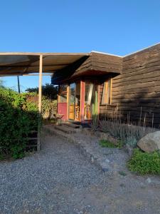 a small wooden house with a red door at Santuario Cosmico Mamalluca in Vicuña +16 photos