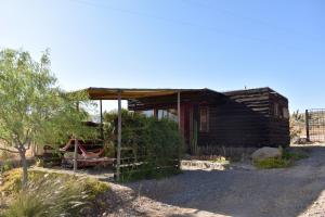a small wooden house with a fence in front of it at Santuario Cosmico Mamalluca in Vicuña