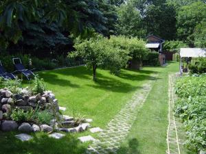 a garden with a stone path and an apple tree at Ferienwohnung Last in Kyritz