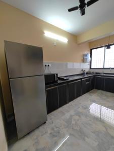 a kitchen with a stainless steel refrigerator in a room at Casa River View in Dabolim