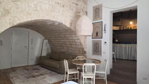 a living room with a table and chairs and a couch at La Caverna - Bari Vecchia, Fronte Mare in Bari