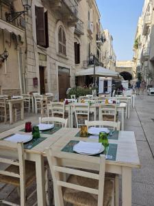 a wooden table and chairs on a street at La Caverna - Bari Vecchia, Fronte Mare in Bari