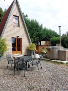 a patio with a table and chairs in front of a house at TIPI de LOUIS in Sarlande