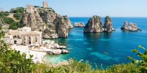 an island with rocks in the water and a building at Appartamento vista mare in Castellammare del Golfo