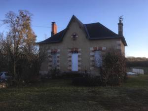 a brick house with a white door in a yard at La porterie in Bignoux
