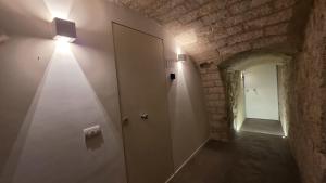 a hallway with a white door and a brick wall at La Caverna - Bari Vecchia, Fronte Mare in Bari +32 photos