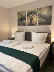 two beds in a room with two paintings on the wall at LV Apartment Externsteine in Horn-Bad Meinberg