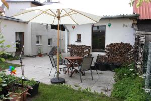 a table and chairs under an umbrella in a yard at Ferienwohnung Hornig in Friedrichroda