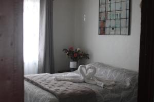 a bed with a white blanket with a bow on it at Arenal Rental in Arenal