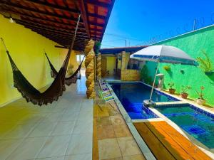 a resort with a hammock and a swimming pool at Lençóis House in Barreirinhas