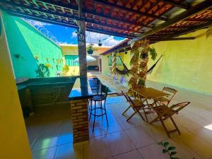 a patio with a table and chairs on a house at Lençóis House in Barreirinhas