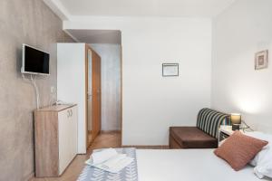 a small bedroom with a bed and a couch at Apartments Jelica in Pag