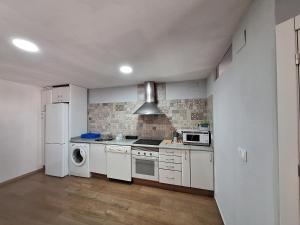 a kitchen with white appliances and a white refrigerator at casa maralba in Fuentelcarro +1 photo