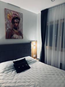 a bedroom with a bed with a large painting on the wall at Davos in Zlatibor