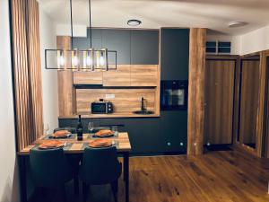a kitchen with a wooden table with chairs and a tableasteryasteryasteryasteryastery at Davos in Zlatibor