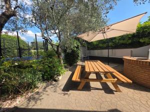 uma mesa de piquenique com um guarda-chuva no pátio em Castelnuovo Workx em Castelnuovo