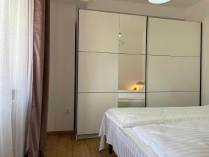 ein Schlafzimmer mit einem großen weißen Schrank und einem Bett in der Unterkunft Apartament Corvin 3 in Hunedoara