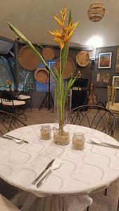 a white table with a vase with flowers on it at The Weekend Farmer in Alfonso