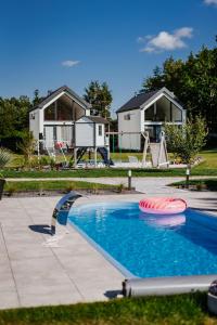 a swimming pool with a house in the background at My Slow Stay Łeba in Szczenurze