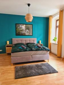 a bedroom with a bed and a blue wall at Stilvolles City-Apartment in Halle an der Saale