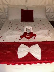 a bed with towels and a bow tie on it at Pousada Vista Gamboa in Camocim +5 photos