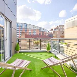 Un balcón con sillas y un césped verde en un edificio. en Big Ben 2 Bed, en Londres