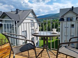 a balcony with two chairs and a table on a balcony at Apartament Pod Gondolą "9" in Świeradów-Zdrój